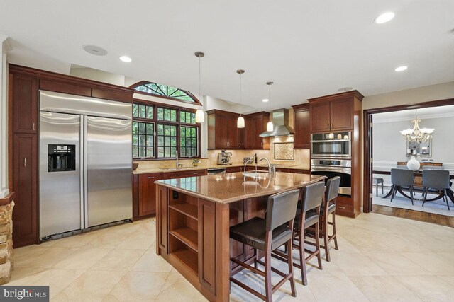 1253 Rowland Dr, Herndon, VA 20170 - kitchen with stainless steel appliances, wall chimney range hood, light stone counters, decorative backsplash, and a chandelier