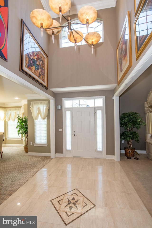 entryway with baseboards, a high ceiling, and a notable chandelier