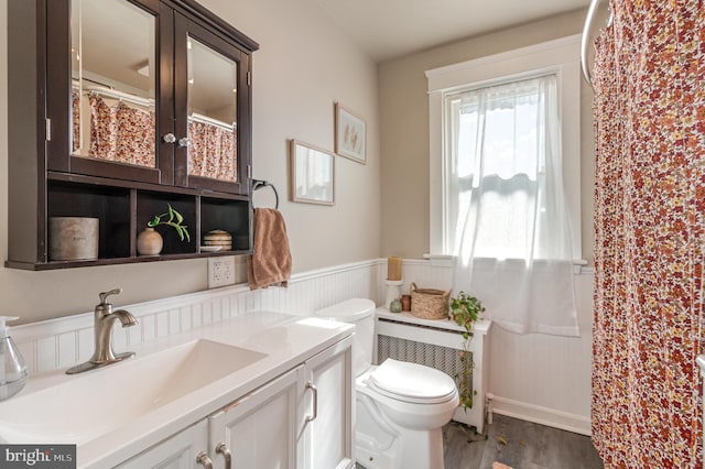 full bathroom featuring toilet, wainscoting, wood finished floors, and vanity