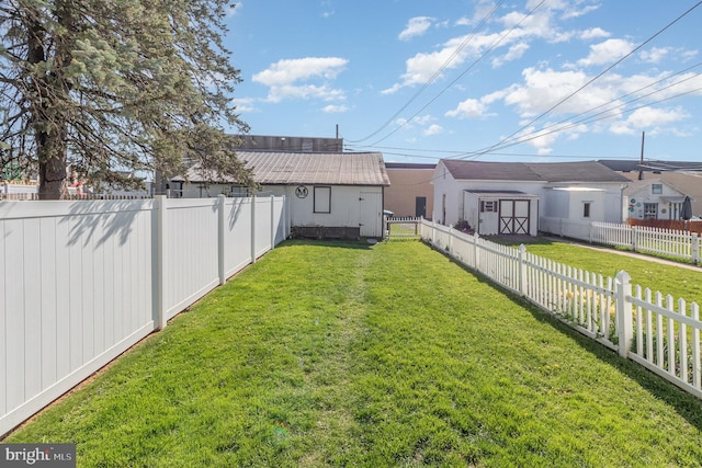 view of yard featuring a fenced backyard, an outdoor structure, and a shed