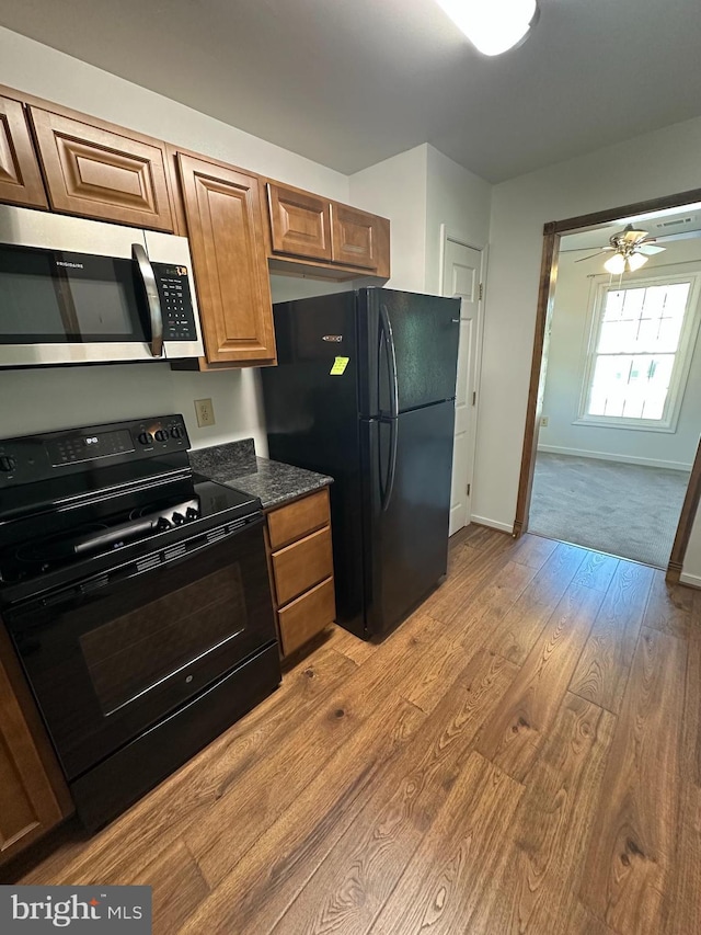 1 Warthens Way Unit H, Emmitsburg, MD 21727 - kitchen with black appliances, wood finished floors, baseboards, brown cabinetry, and dark stone countertops