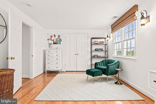 sitting room featuring light wood-style floors, baseboards, and visible vents