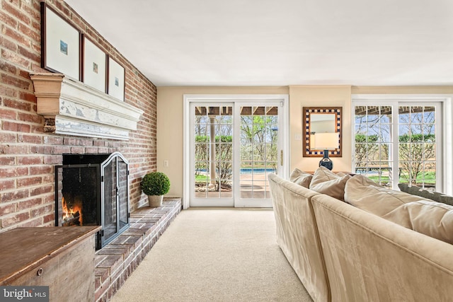 carpeted living room with a healthy amount of sunlight and a brick fireplace