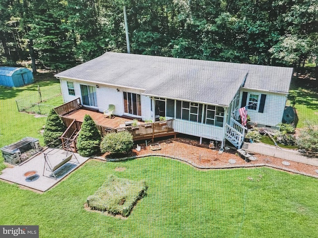 back of house featuring a storage shed, a lawn, a wooden deck, a sunroom, and stairway