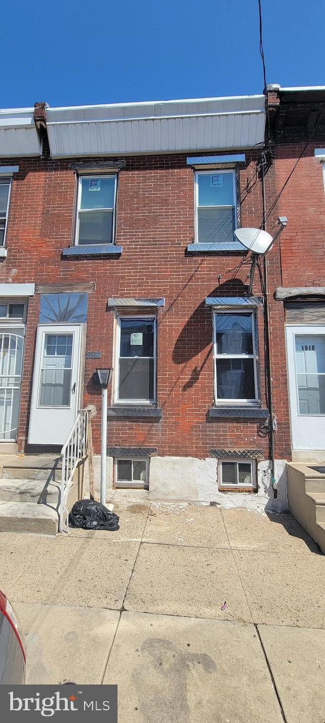 multi unit property featuring entry steps and brick siding