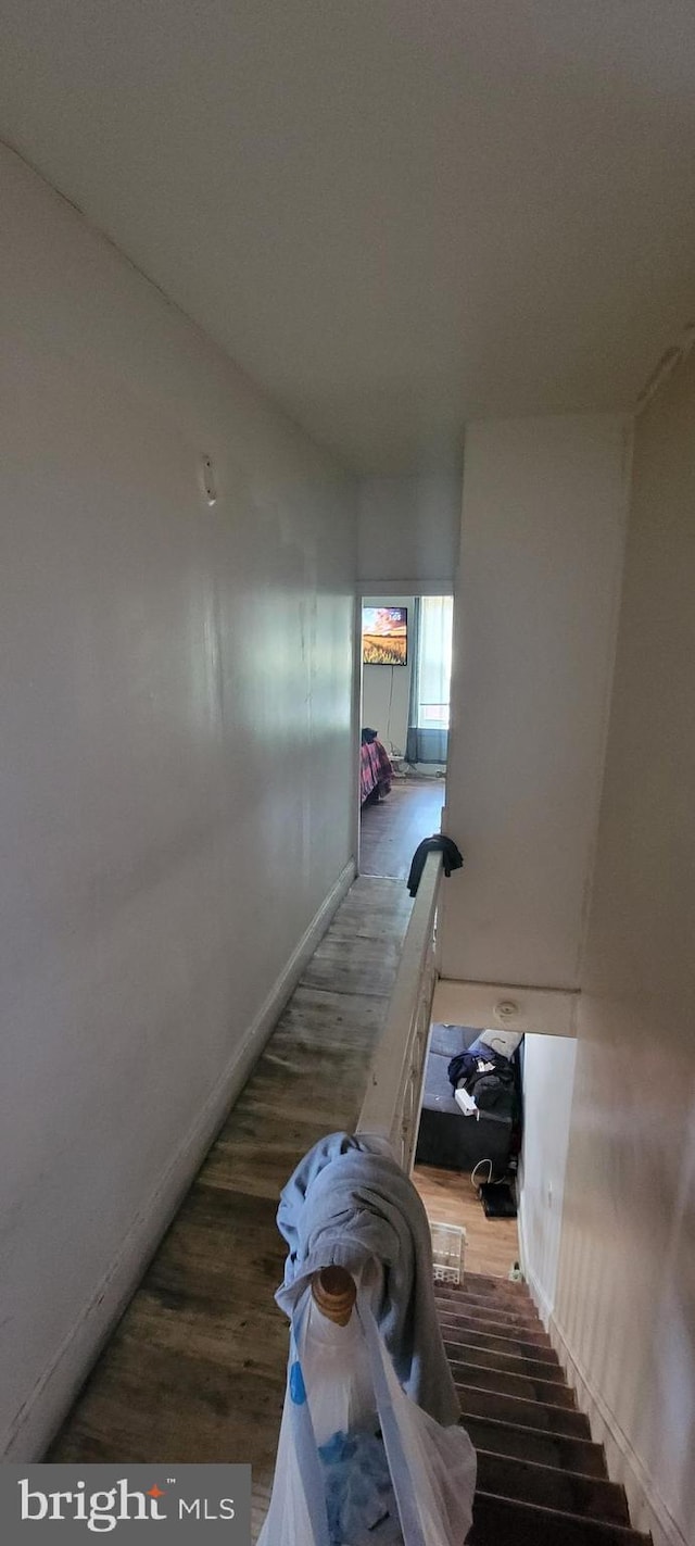 stairs with wood finished floors and baseboards