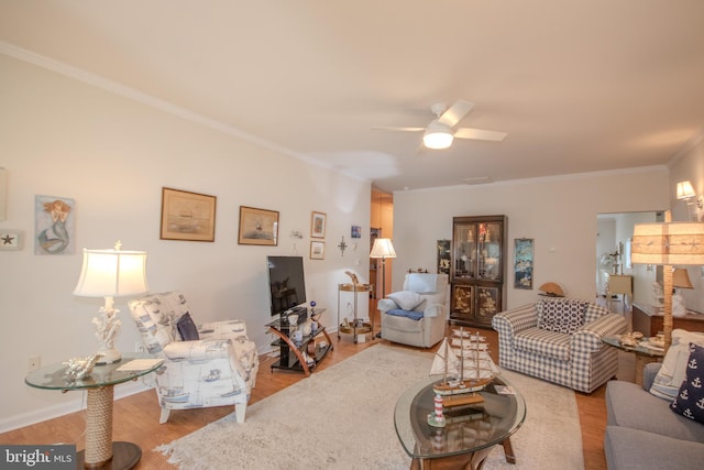 living area with crown molding, ceiling fan, and wood finished floors