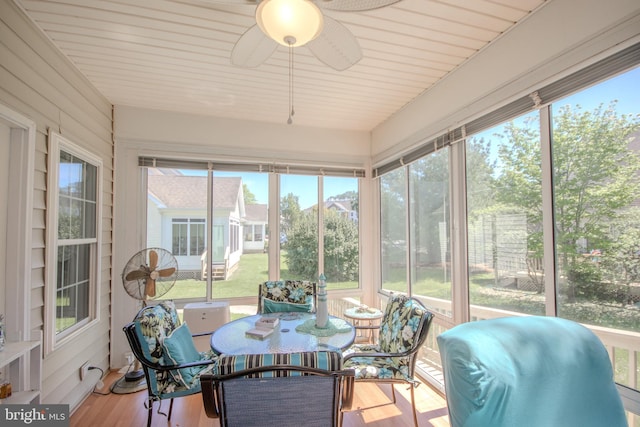sunroom with ceiling fan and outdoor dining space