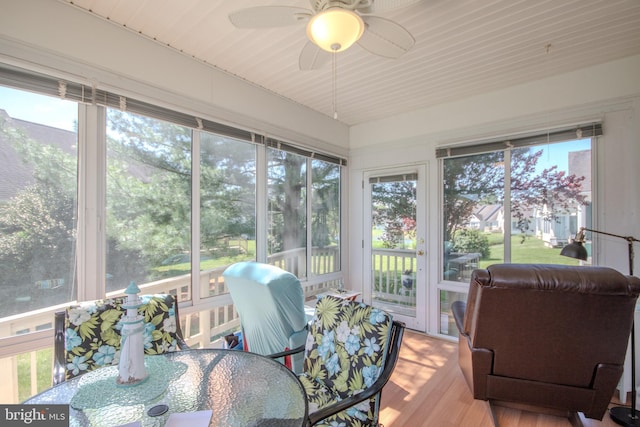 sunroom featuring a ceiling fan, outdoor dining area, and a wealth of natural light