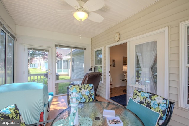 sunroom featuring a ceiling fan and outdoor dining area