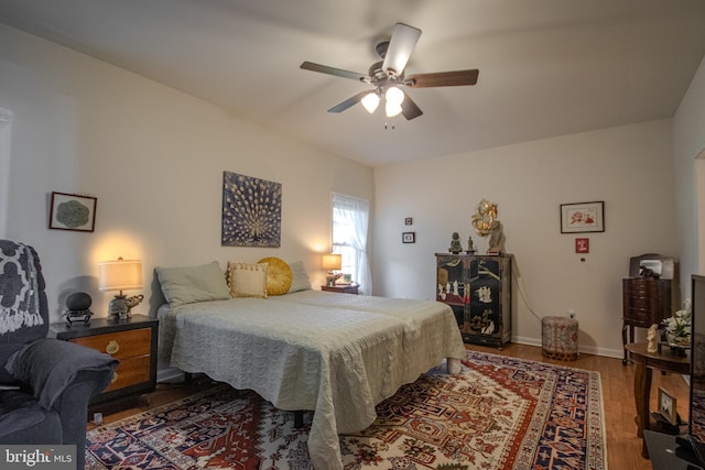 bedroom featuring baseboards, ceiling fan, and wood finished floors
