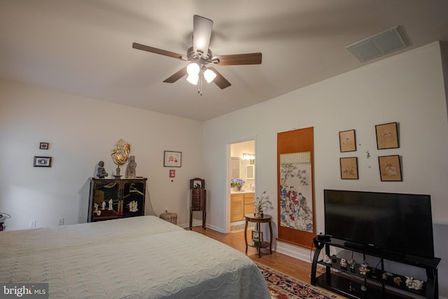 bedroom featuring a ceiling fan, visible vents, baseboards, connected bathroom, and light wood-style flooring
