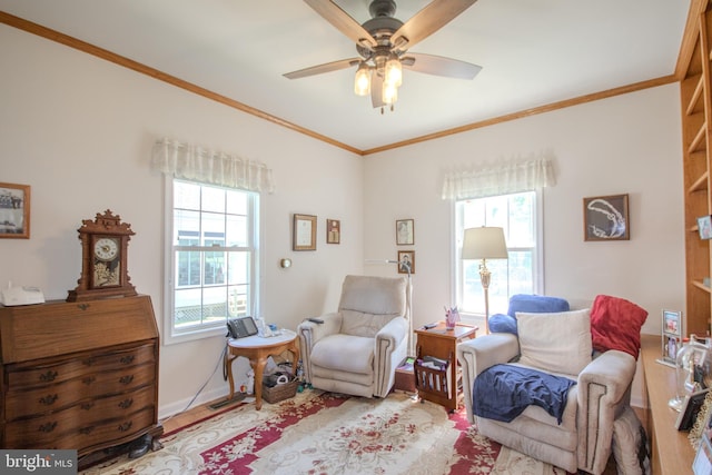 living area with ceiling fan, ornamental molding, and wood finished floors