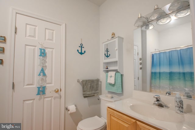 full bath featuring vanity, curtained shower, and toilet