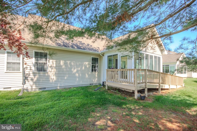 back of house with crawl space, roof with shingles, a wooden deck, a sunroom, and a yard