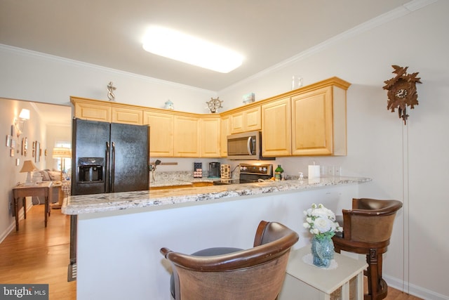 kitchen featuring range with electric stovetop, light brown cabinetry, stainless steel microwave, a peninsula, and black fridge