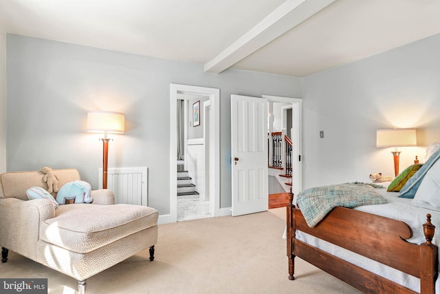 bedroom with beam ceiling, light carpet, connected bathroom, and baseboards