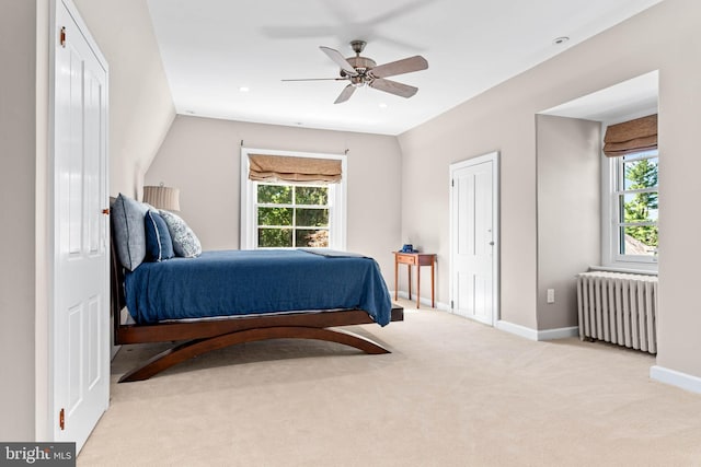 bedroom with radiator, multiple windows, carpet, and baseboards