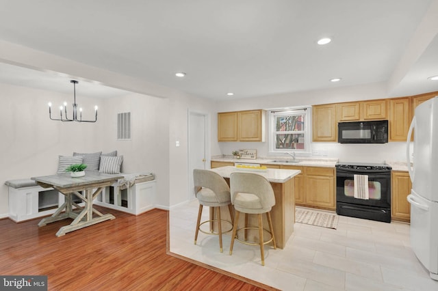 kitchen featuring a sink, a center island, recessed lighting, visible vents, and black appliances
