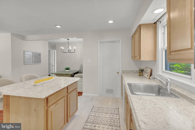 kitchen featuring visible vents, a sink, light brown cabinets, and light countertops