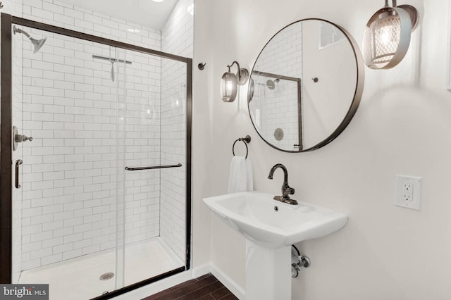 full bath featuring baseboards, a stall shower, and wood finished floors
