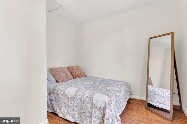 bedroom with baseboards and wood finished floors