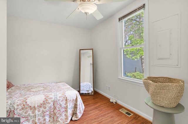 bedroom with a ceiling fan, baseboards, visible vents, and light wood finished floors