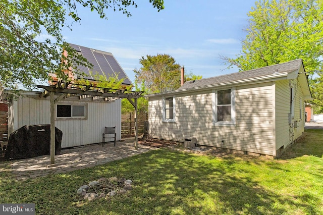 back of property with solar panels, a patio, fence, a yard, and a pergola