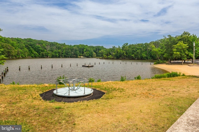 property view of water featuring a dock and a forest view