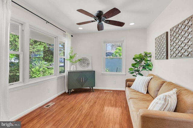 living area with visible vents, baseboards, light wood-style floors, ceiling fan, and recessed lighting