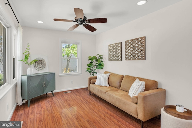 living room with a ceiling fan, visible vents, wood finished floors, baseboards, and recessed lighting