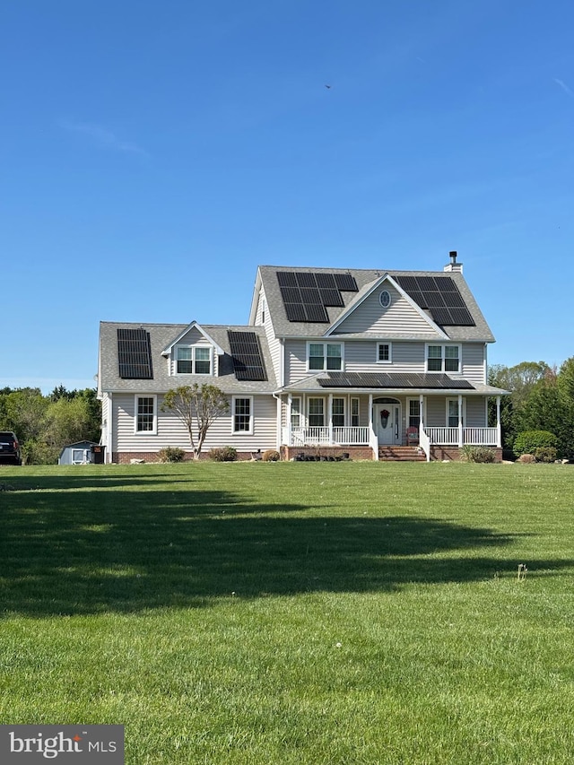 view of front of house with roof mounted solar panels, a front yard, and covered porch