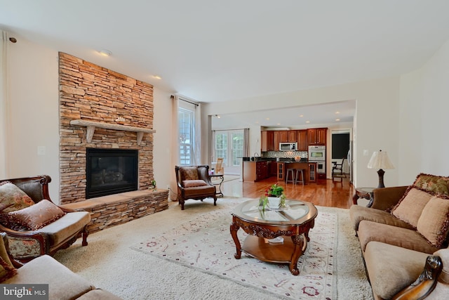 living area with a stone fireplace and recessed lighting