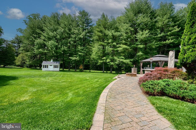 view of green lawn featuring a gazebo and an outbuilding