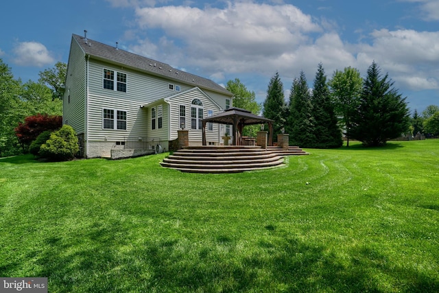 back of property featuring a gazebo and a yard