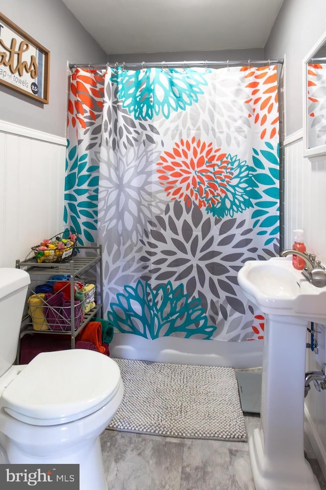 full bathroom with toilet and wainscoting