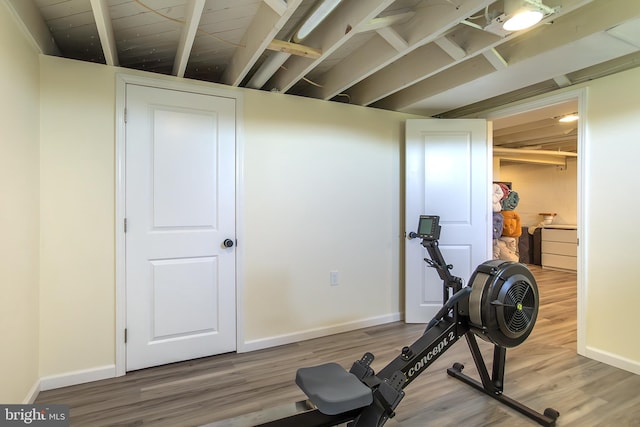 exercise room with wood finished floors and baseboards