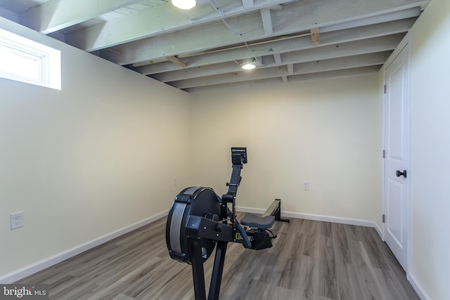 exercise room with wood finished floors and baseboards