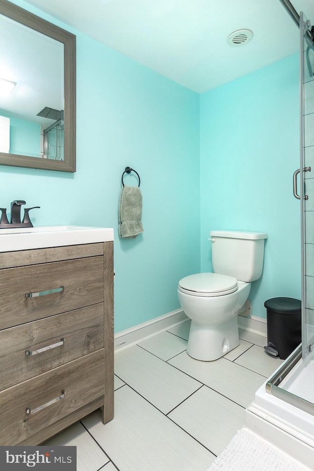 bathroom featuring baseboards, a shower stall, toilet, and vanity