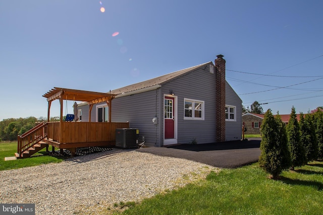 back of property featuring a pergola, a deck, a chimney, and central air condition unit