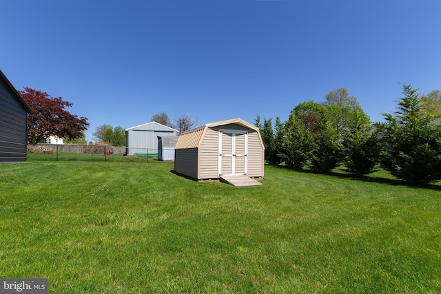 view of yard featuring an outdoor structure, a storage shed, and fence