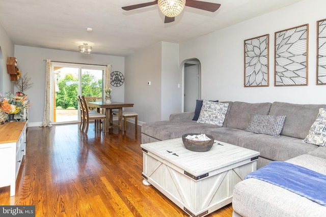 living room featuring arched walkways, a ceiling fan, and wood finished floors