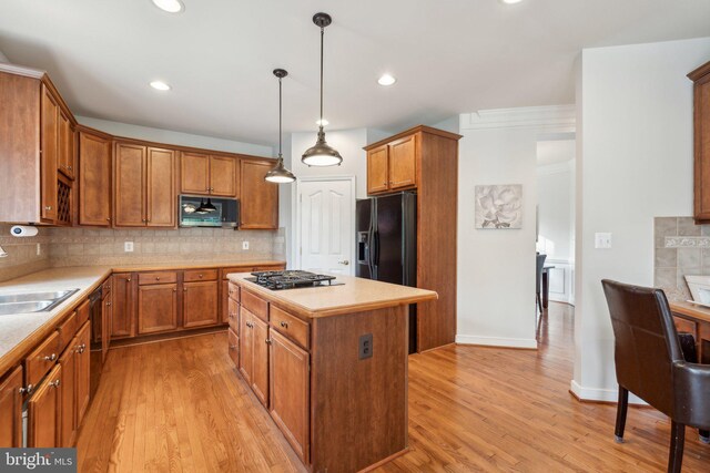 6 Crawford Ln, Stafford, VA 22556 - kitchen featuring decorative backsplash, a center island, a sink, light wood finished floors, and black appliances