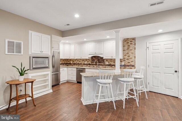 6 Crawford Ln, Stafford, VA 22556 - kitchen featuring a breakfast bar area, stainless steel appliances, a peninsula, and visible vents