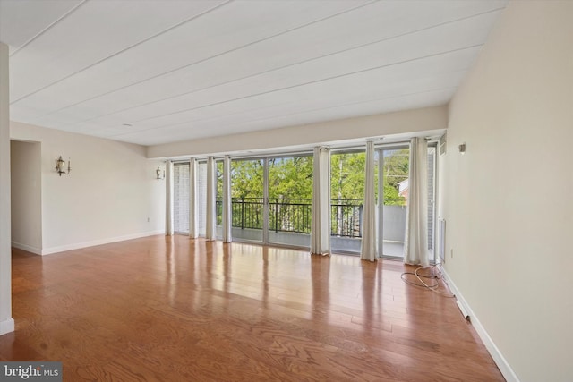 unfurnished room with baseboards and wood finished floors
