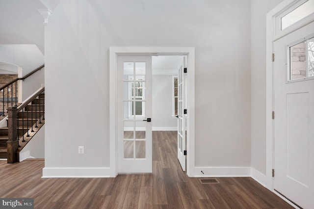 entrance foyer with baseboards, dark wood finished floors, visible vents, and stairway