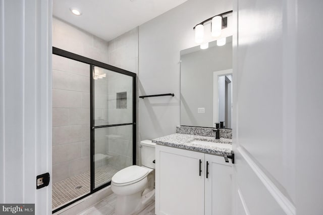 bathroom with vanity, toilet, and a shower stall
