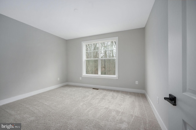 empty room featuring carpet flooring, baseboards, and visible vents