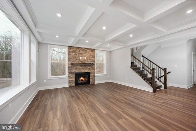unfurnished living room with dark wood-style flooring, beam ceiling, a fireplace, stairway, and coffered ceiling