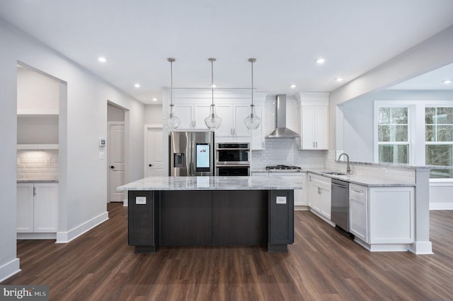 kitchen with dark wood-style floors, wall chimney range hood, a center island, a sink, and appliances with stainless steel finishes